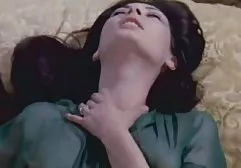 充满激情的丰满的黑发女郎抚摸她柔软的沙发上的阴部